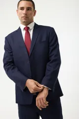 Ambo formal compuesto por saco de dos botones con solapas clásicas y bolsillos con solapa, y pantalón de vestir a juego, confeccionado en tela de alta calidad color azul marino.