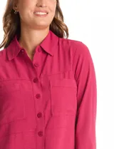 Camisa de crepe color beige con cuello clásico, cierre frontal con botones y dos bolsillos aplicados en el pecho.