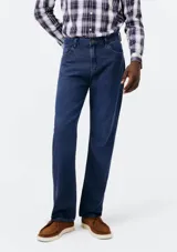 Pantalón de jean de corte slim, color azul clásico, con cierre de botón y cremallera, bolsillos laterales y traseros.