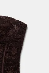 Corsé de encaje negro con escote corazón, hombros descubiertos y varillas interiores para estructura. Cuenta con cierre lateral mediante cremallera oculta.