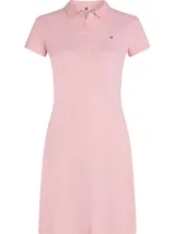 Vestido corto Tommy Hilfiger tipo chomba, color rosado, de corte slim, confeccionado en piqué de algodón orgánico elástico. Presenta cuello de chomba, cartera de cinco botones y logo de Tommy Hilfiger bordado en el pecho.