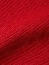 Sweater rojo de tejido de punto con cuello redondo y logo de la marca bordado en el pecho.