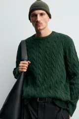 Jersey de punto con diseño de trenzas verticales, cuello redondo y manga larga. Presenta un ajuste regular y acabados en rib en cuello, puños y ruedo.