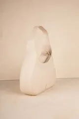 Mini bag color crema en símil cuero texturizado con asa fija.