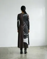 Vestido largo de corte fluido en tejido jersey, con escote en V y mangas largas. Presenta un diseño estampado con trazos orgánicos abstractos en color blanco sobre base negra.