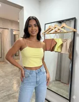 Top corto de breteles finos con escote recto, confeccionado en tela suave y elástica. Diseño básico y versátil, ideal para combinar con diversas prendas.