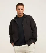 Campera deportiva negra con capucha, cierre frontal con cremallera, bolsillos laterales y puños elásticos.