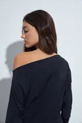 Top de manga larga con escote bote amplio, diseñado para usar ligeramente caído sobre los hombros. Presenta una silueta entallada y tejido liso, liviano y adaptable al cuerpo.