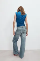 Jeans de denim de tiro medio y corte relaxed con diseño de cinco bolsillos, trabillas en la cintura y cierre frontal con cremallera y botón metálico.