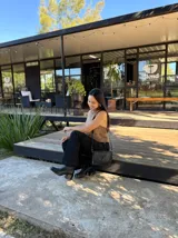 Bota corta de cuero negro con punta cuadrada y taco bloque de altura media con textura grabada. Presenta un diseño minimalista con costura central vertical y cierre lateral interno.