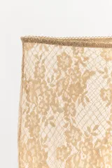 Pantalón tipo legging de encaje color dorado/beige, con patrón floral y acabado semitransparente. Presenta cintura y puños elásticos.
