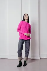 Sweater de punto con textura de ochos verticales, cuello redondo, mangas largas con puños acanalados y silueta relajada.