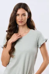 Remera de algodón color verde menta, con escote redondo y mangas corta con detalles de volados sutiles en los puños.