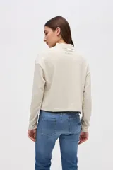 Remera de manga larga con cuello polera, confeccionada en tela texturizada con calce relajado.