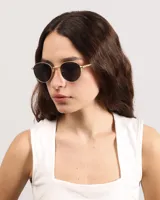 Lentes de sol con montura dorada y cristales negros ovalados.