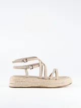 Sandalia con plataforma de esparto, tiras delanteras a diferentes niveles y cierre con hebilla al tobillo.