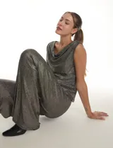 Pantalón modelo palazzo de tiro alto con pretina ancha elastizada, confeccionado en tejido metalizado con textura acanalada.