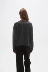 Sweater de punto con diseño de rombos argyle en tonos gris, bordó y gris claro. Presenta cuello redondo, mangas largas y un corte holgado.