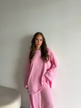 Buzo de punto morley color rosado, con cuello redondo y diseño oversize de mangas largas.
