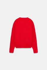 Jersey de punto color rojo, con escote en pico y manga larga. Los puños y el bajo tienen acabados en rib.