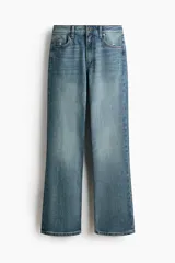 Jean de tiro alto y corte bootcut, confeccionado en denim de algodón levemente elástico con lavado azul medio y efecto desgastado. Presenta diseño clásico de cinco bolsillos, cierre de cremallera y botón metálico.