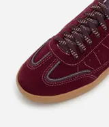 Championes estilo chutera color bordó, con recortes pespunteados, cordones con detalles contrastantes y suela de goma color caramelo.