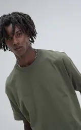 Remera de manga corta y cuello redondo, color verde militar, con calce boxy fit, caracterizada por ser ligeramente más corta y tener mangas amplias.