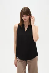 Musculosa de poliéster color blanco, con cuello en V y diseño holgado sin mangas.