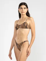 Bikini de dos piezas con estampado animal print en tonos rosado y naranja. El corpiño es de breteles finos y se ata en la espalda. La bombacha es de tiro bajo con cobertura mínima.