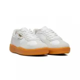 Championes Puma modelo Palermo, de diseño retro con combinación de cuero y gamuza en tonos blanco y beige, con suela de goma color caramelo y detalles en dorado.