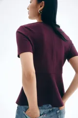 Top de manga corta color borgoña, con escote redondo y peplum acampanado en la cintura.