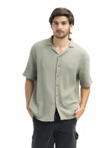 Camisa color crema de tela tetra de algodón, de corte suelto, manga corta y cuello cubano.