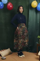 Falda midi de corte amplio con diseño a cuadros, cintura elastizada y frunces laterales.