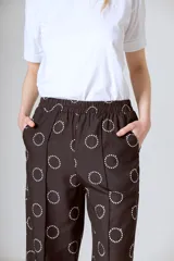 Pantalón de vestir negro con estampado de círculos blancos, corte holgado y tiro alto.