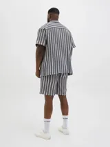 Camisa de manga corta con cuello resort y fit regular. Tejido plano de sarga con textura suave y caída ligera. Cierre frontal con botones.