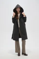 Tapado de paño color gris oscuro con solapas anchas, cierre frontal cruzado con botones y cinturón ajustable a la cintura. Posee mangas largas y bolsillos laterales.