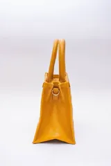 Cartera pequeña color beige, con diseño acolchado en forma de rombos. Tiene doble asa corta y correa larga desmontable y regulable.