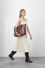 Vestido midi sin mangas de color azul oscuro, con escote cuadrado y silueta evasé. Presenta costuras a contratono en color blanco que recorren verticalmente el diseño, aportando estructura y un detalle gráfico. Confeccionado en tejido con cuerpo y caída firme.