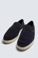 Mocasín casual de hombre, color azul marino, con parte superior de serraje (gamuza) y suela de goma a contraste color beige. Presenta un detalle de bordón cosido en la pala.