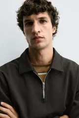 Sudadera polo azul marino de corte regular fit, confeccionada en tejido técnico interlock de algodón con elasticidad. Presenta cuello solapa, cierre frontal de cremallera y manga larga con acabados en rib.