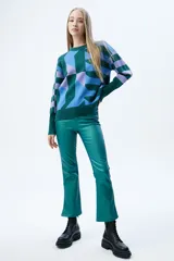Sweater de tejido de punto con diseño geométrico multicolor en tonos verde, azul y lila. Presenta cuello redondo, mangas largas con puños acanalados y corte recto.