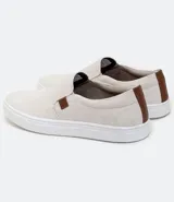Championes tipo slip on marca Viko, de color negro con suela de goma blanca. Presenta un diseño minimalista sin cordones con paneles elásticos laterales y un pequeño detalle de etiqueta en color marrón.