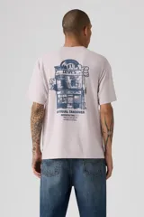 Remera de corte holgado estilo vintage de la marca Levi's, en color gris claro, con cuello redondo y mangas cortas. Presenta un pequeño estampado gráfico en el pecho con el logotipo de la marca y la inscripción "Music City".