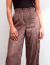 Pantalón wide leg de tiro alto con estampado animal print en tonos marrones. Presenta pretina ancha, cierre frontal con broche y bolsillos laterales aplicados.