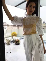 Remera blanca de algodón con estampado color cobre y mangas de broderie negro con elástico.