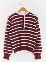 Sweater de punto a rayas horizontales en color bordó y blanco, con cuello tipo polo, cierre frontal con botones y delicados detalles de puntilla blanca en el cuello y los puños.