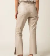 Pantalón de cuero ovino italiano color crema, de corte recto con tajos laterales en el ruedo.