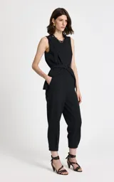 Pantalón sastrero de corte recto y tiro alto, confeccionado en tejido de punto con estampado de raya diplomática. Presenta cintura estructurada con trabillas, pliegues frontales, bolsillos traseros de ribete y cierre frontal con cremallera y corchetes.