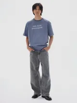 Pantalón de jean gris oscuro con efecto lavado, tiro medio y calce loose con pierna ancha de caída recta.