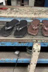 Ojotas de cuero vacuno color negro, con tiras en forma de Y adornadas con tachas metálicas plateadas.